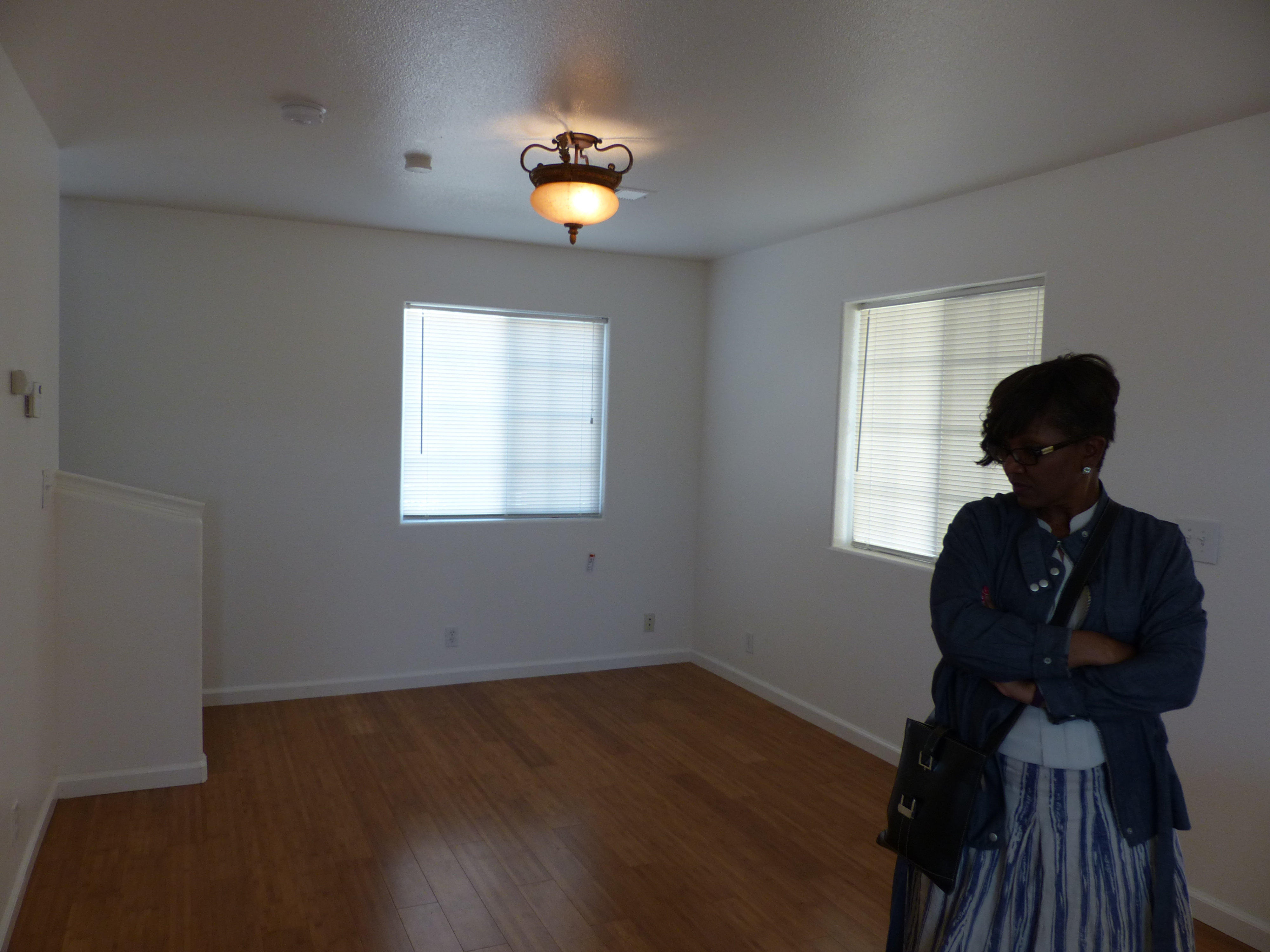 Empty living room with lady standing on right